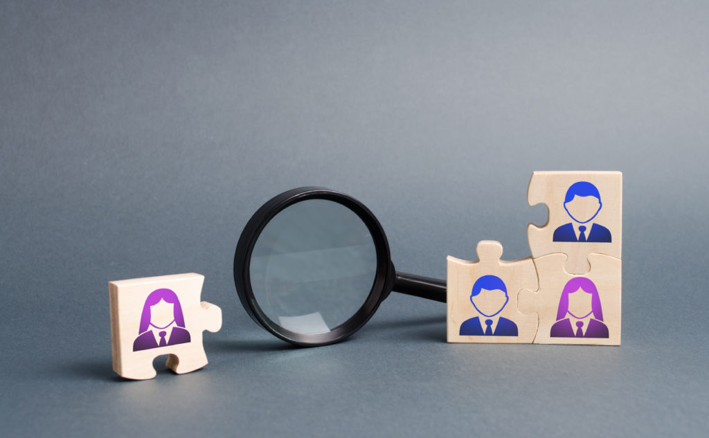 Unsorted team puzzle and magnifying glass. Search, recruitment staff, hiring leader. Lack of specialists in the labor market. Creating an efficient and productive business unit